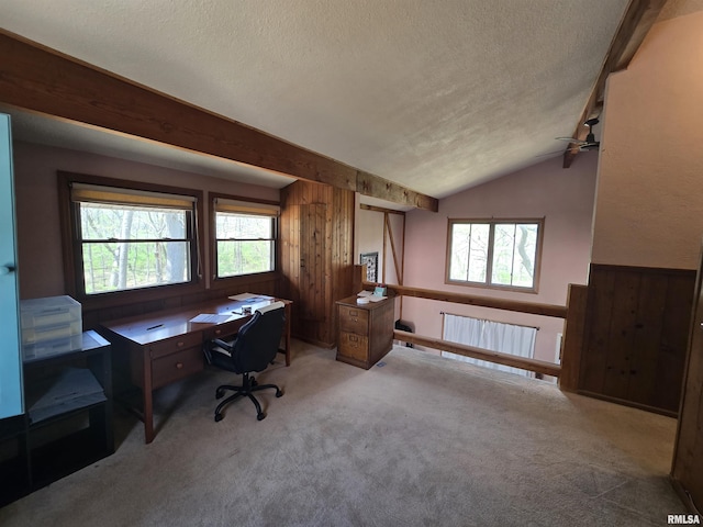 carpeted office featuring ceiling fan, a textured ceiling, wood walls, radiator heating unit, and vaulted ceiling