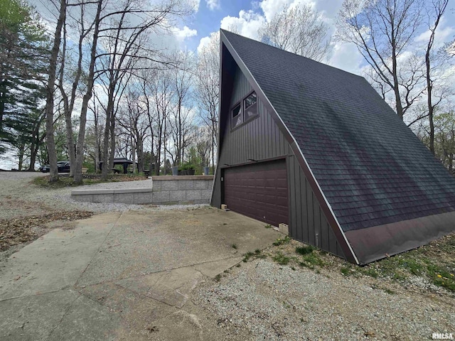 exterior space with roof with shingles and a garage