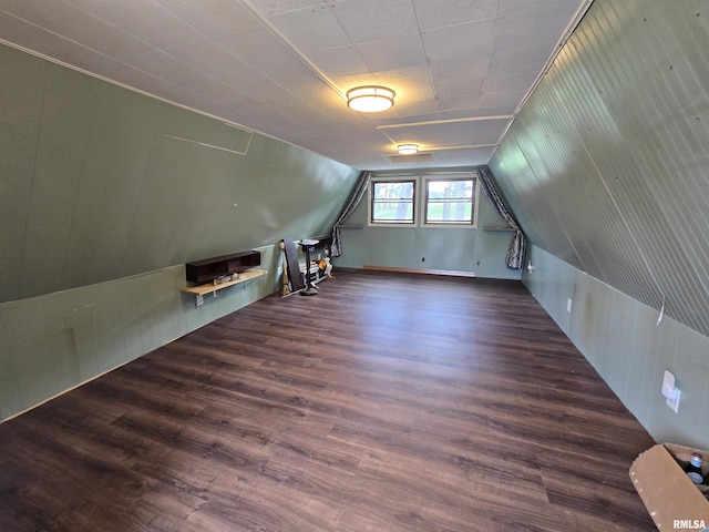additional living space featuring vaulted ceiling, wood walls, and wood finished floors