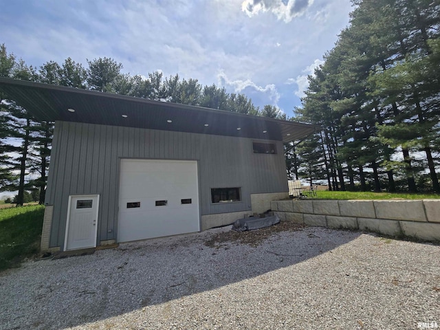 view of home's exterior with brick siding, an outdoor structure, and a garage