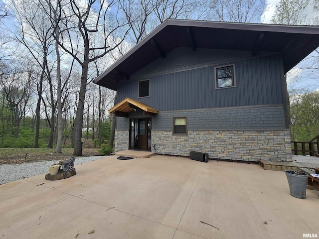 view of side of property featuring a patio area and stone siding
