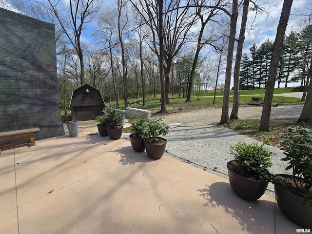 view of patio featuring a garage, a barn, and an outdoor structure