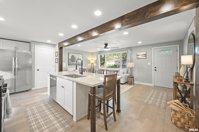 kitchen with ceiling fan, beam ceiling, a sink, stainless steel appliances, and recessed lighting