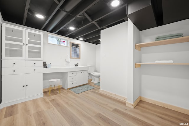 bathroom with baseboards, vanity, toilet, and wood finished floors