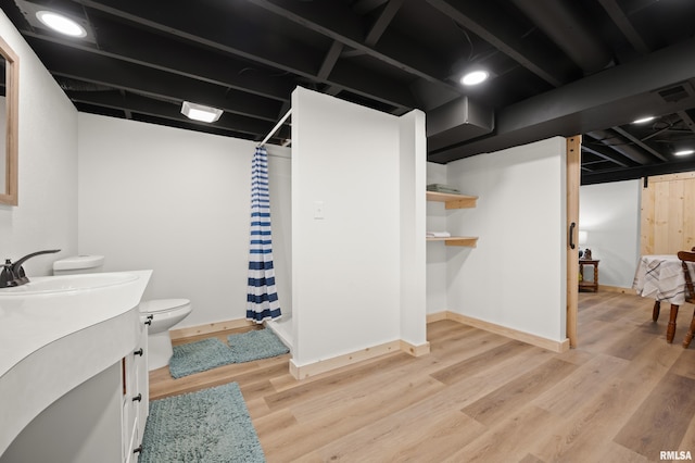 bathroom featuring vanity, toilet, wood finished floors, a shower with curtain, and visible vents
