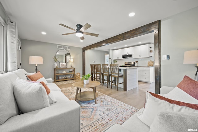 living room with light wood-style floors, a ceiling fan, recessed lighting, and visible vents