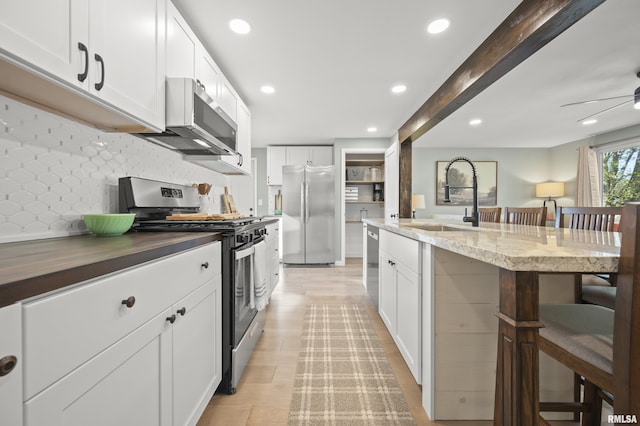 kitchen with a ceiling fan, backsplash, appliances with stainless steel finishes, a sink, and recessed lighting