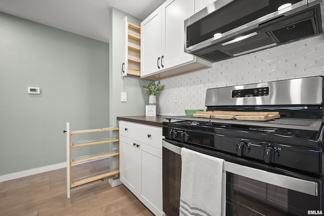 kitchen with open shelves, white cabinets, light wood-style flooring, backsplash, and stainless steel appliances