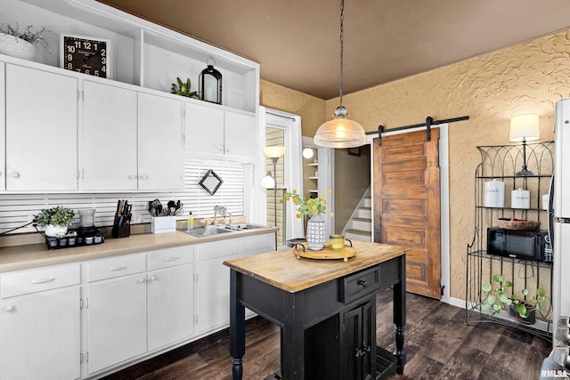1122 N Broad St, Galesburg, IL 61401 - kitchen featuring black microwave, a barn door, light countertops, a sink, and a textured wall