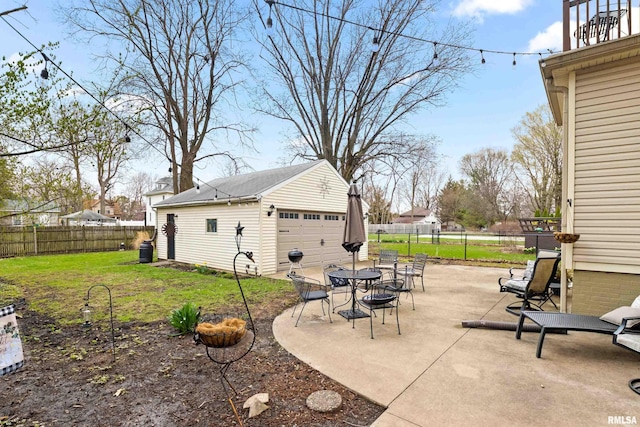 1122 N Broad St, Galesburg, IL 61401 - view of patio with a fenced backyard, a detached garage, and an outbuilding