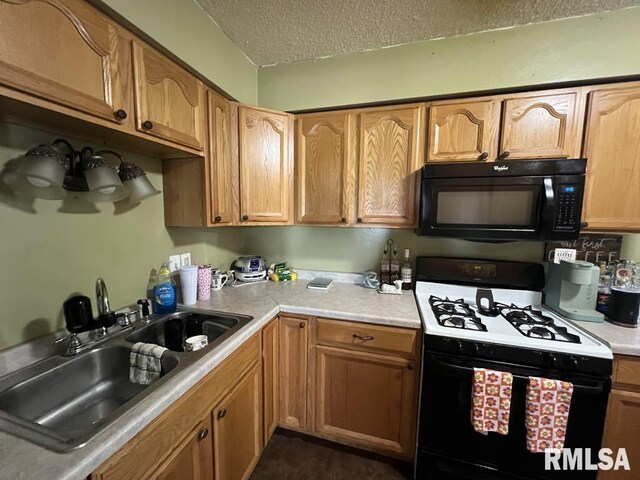 1520 E Wheeler St, Macomb, IL 61455 - kitchen with light countertops, a textured ceiling, a sink, and black appliances