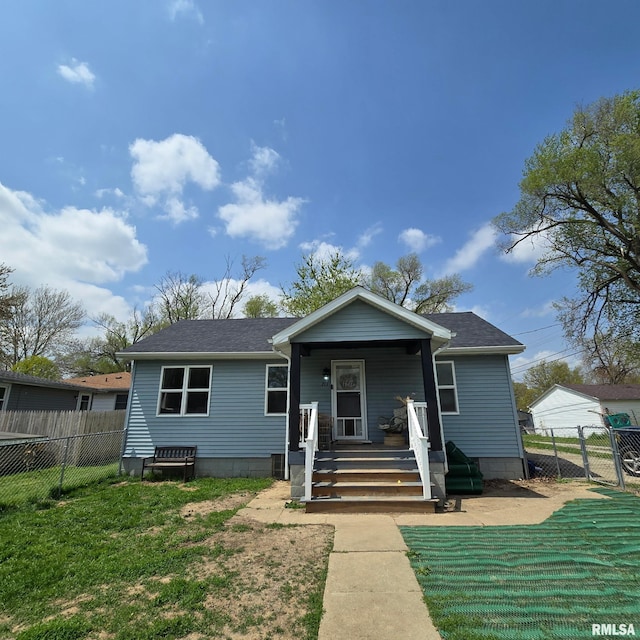 bungalow-style house featuring fence, a shingled roof, and a front lawn