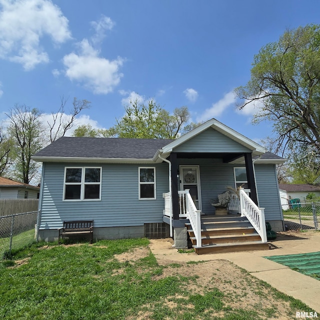 view of front of home featuring fence, a shingled roof, and a front yard