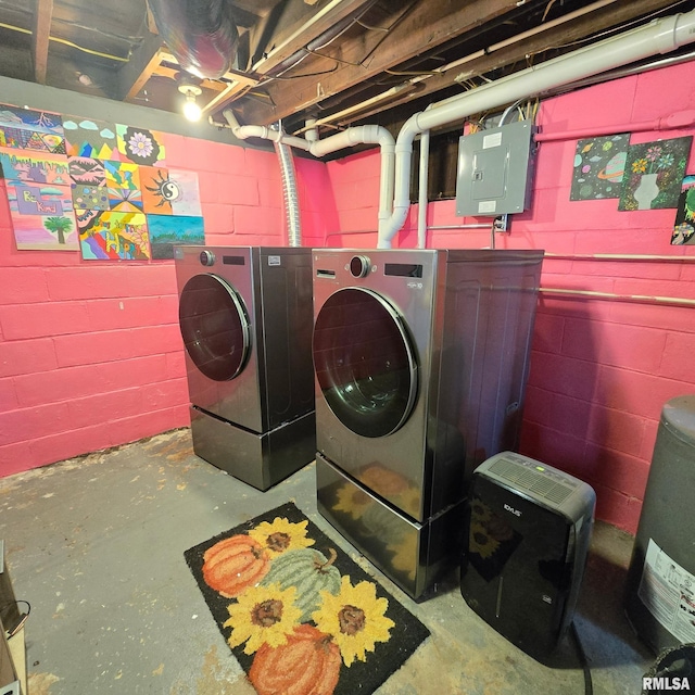 washroom with laundry area, washing machine and dryer, electric panel, and concrete block wall