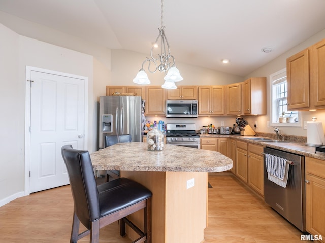 kitchen with appliances with stainless steel finishes, a kitchen island, light brown cabinets, and a sink