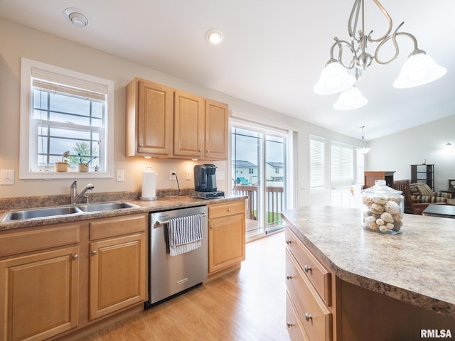 kitchen with a wealth of natural light, stainless steel dishwasher, light wood-style flooring, and a sink