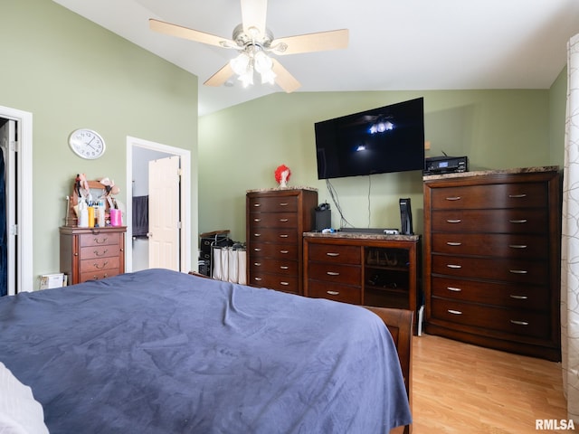 bedroom featuring a ceiling fan, light wood-type flooring, and lofted ceiling
