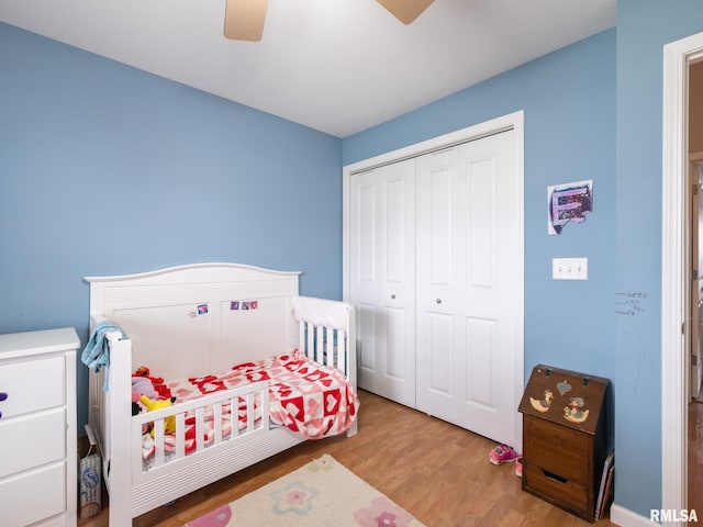 bedroom featuring a closet, wood finished floors, and ceiling fan