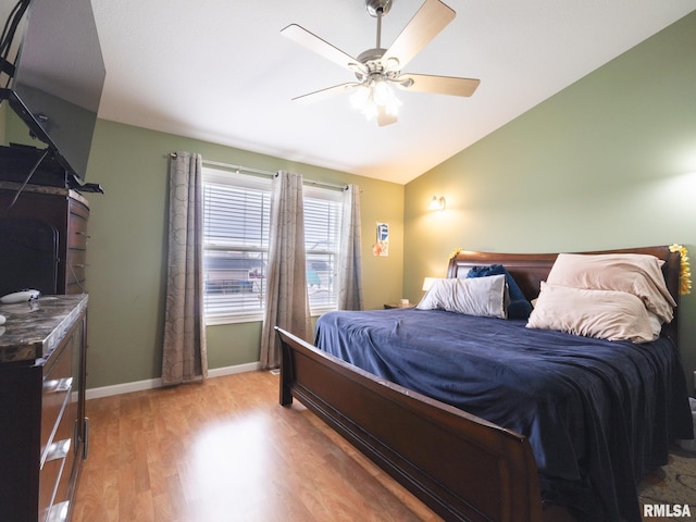 bedroom with baseboards, wood finished floors, lofted ceiling, and ceiling fan