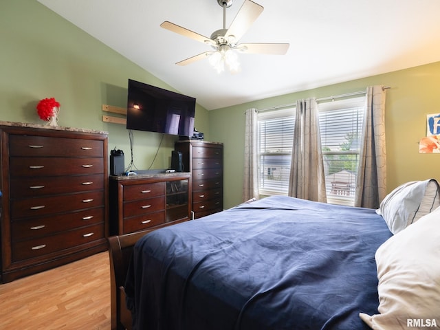 bedroom featuring light wood-style floors, vaulted ceiling, and ceiling fan