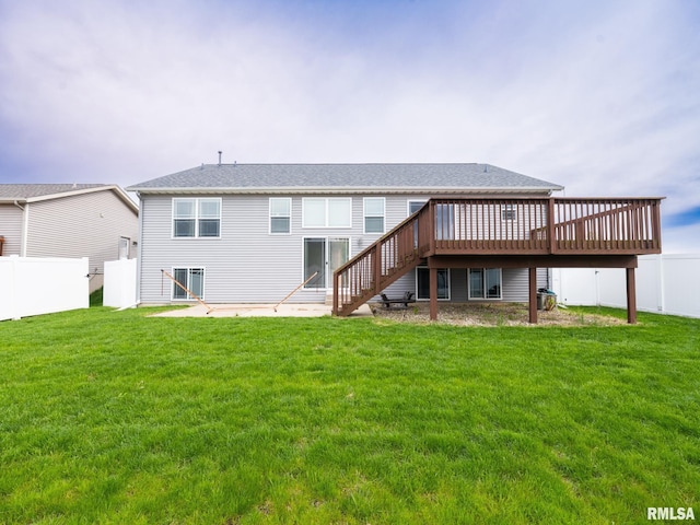 back of house featuring a yard, fence, a deck, and stairs