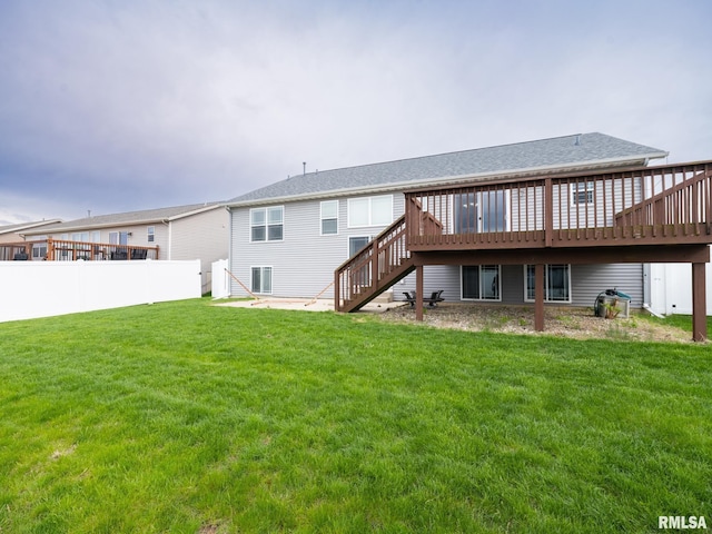 rear view of property featuring a yard, stairway, fence, and a wooden deck