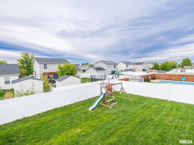 view of yard featuring a playground, a residential view, and a fenced backyard