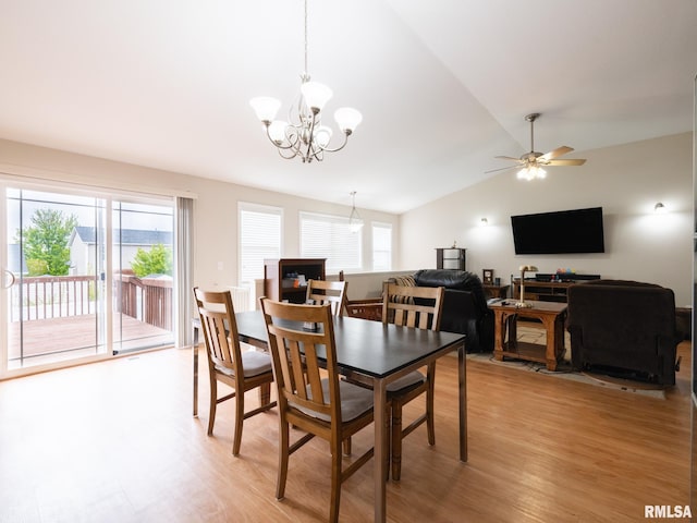 dining area with lofted ceiling, ceiling fan with notable chandelier, and light wood-type flooring