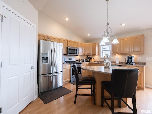 kitchen featuring light brown cabinets, light wood-style flooring, appliances with stainless steel finishes, and vaulted ceiling