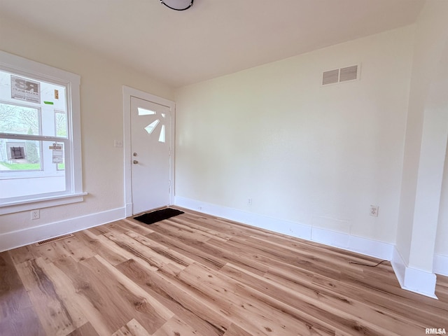 entryway with baseboards, visible vents, and wood finished floors