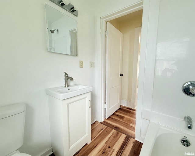 bathroom with vanity, bathtub / shower combination, toilet, and wood finished floors