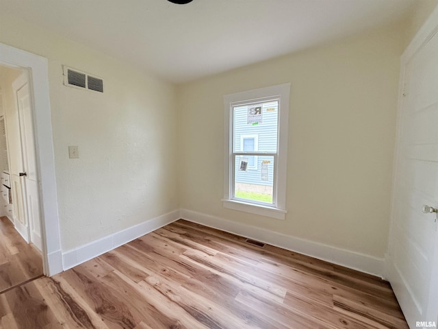spare room with baseboards, visible vents, and light wood-type flooring