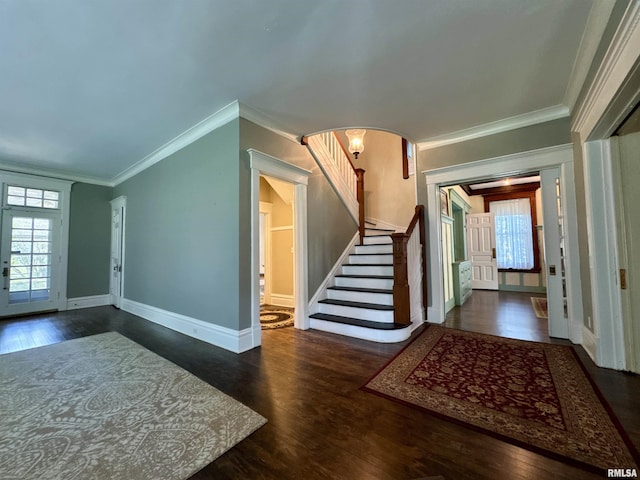 foyer with ornamental molding, stairs, wood finished floors, baseboards, and arched walkways