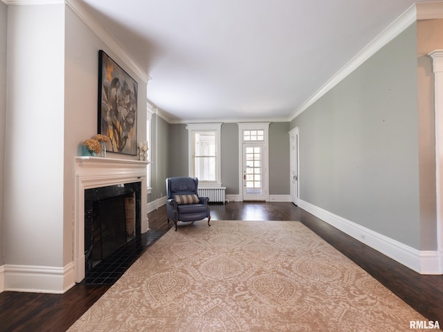 sitting room featuring a high end fireplace, crown molding, baseboards, dark wood-style floors, and radiator heating unit