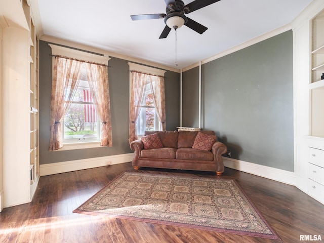 interior space with baseboards, ceiling fan, ornamental molding, and wood finished floors