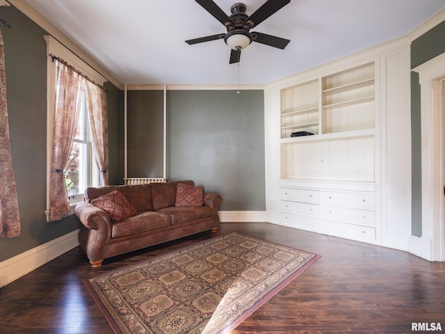 living area with baseboards, ceiling fan, and wood finished floors