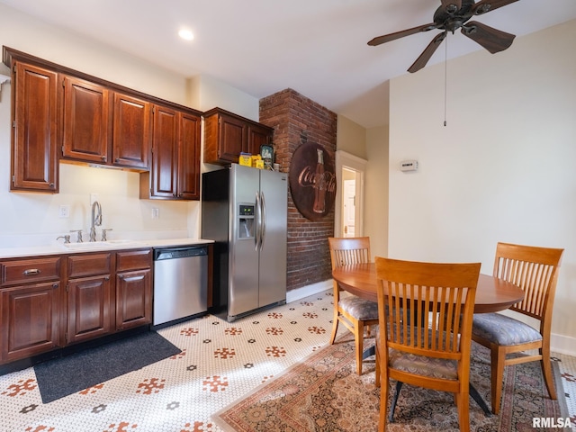 kitchen featuring ceiling fan, a sink, light countertops, stainless steel appliances, and baseboards