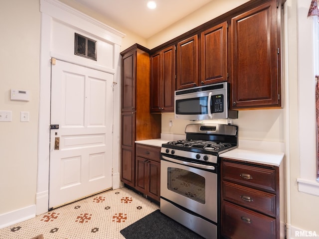 kitchen with light countertops, stainless steel appliances, baseboards, and visible vents