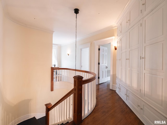 corridor with ornamental molding, dark wood-style flooring, and an upstairs landing