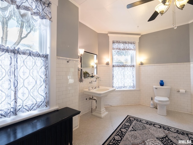 bathroom with tile walls, tile patterned flooring, and wainscoting