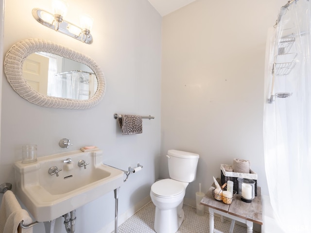 full bath featuring a sink, toilet, tile patterned floors, a shower with shower curtain, and baseboards
