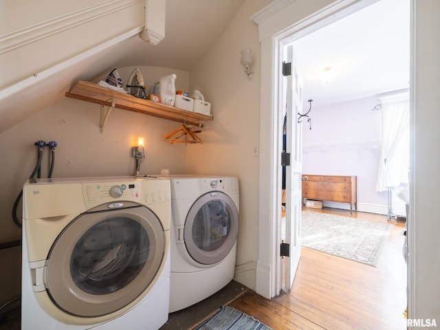 laundry area featuring separate washer and dryer, laundry area, and wood finished floors