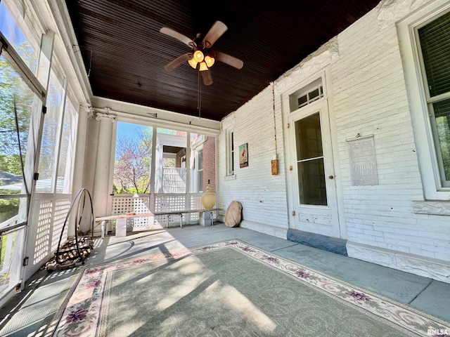unfurnished sunroom with a ceiling fan