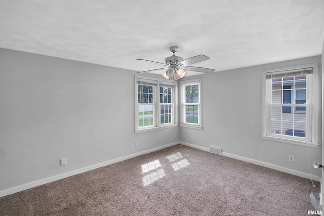 empty room featuring visible vents, carpet, ceiling fan, and baseboards