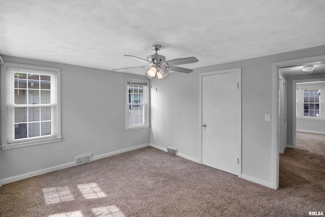 unfurnished bedroom with carpet floors, baseboards, and visible vents