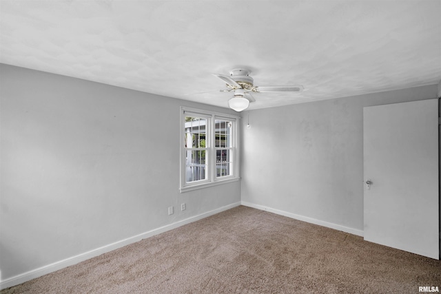 carpeted spare room with baseboards and ceiling fan