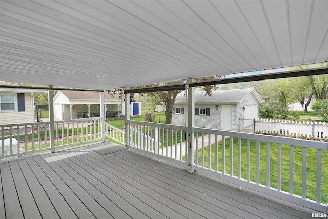 wooden deck featuring a lawn, a residential view, and an outdoor structure