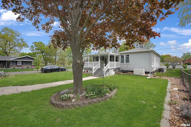 view of front of home featuring a sunroom, fence private yard, and a front yard