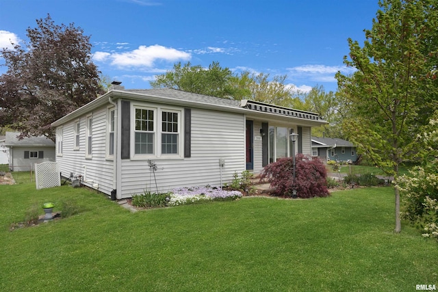 view of front of home with fence, a chimney, and a front lawn