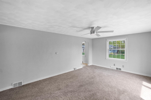 spare room featuring visible vents, a ceiling fan, baseboards, and carpet floors